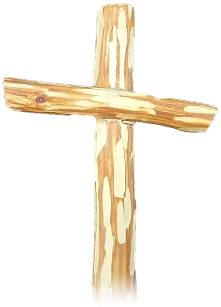 A hand-carved wooden cross, peeled pale with flecks of golden bark left in the grain